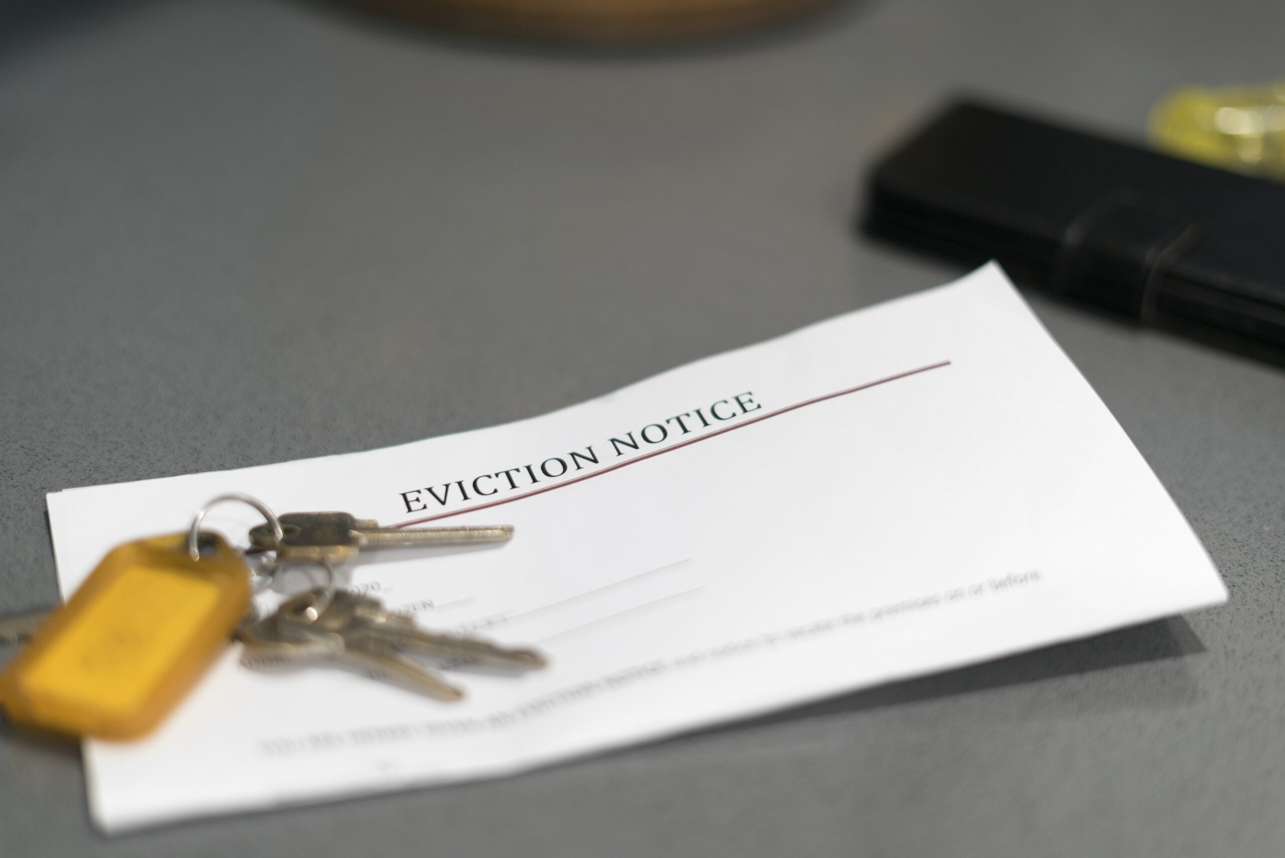 House keys sitting on an eviction notice received in the mail.