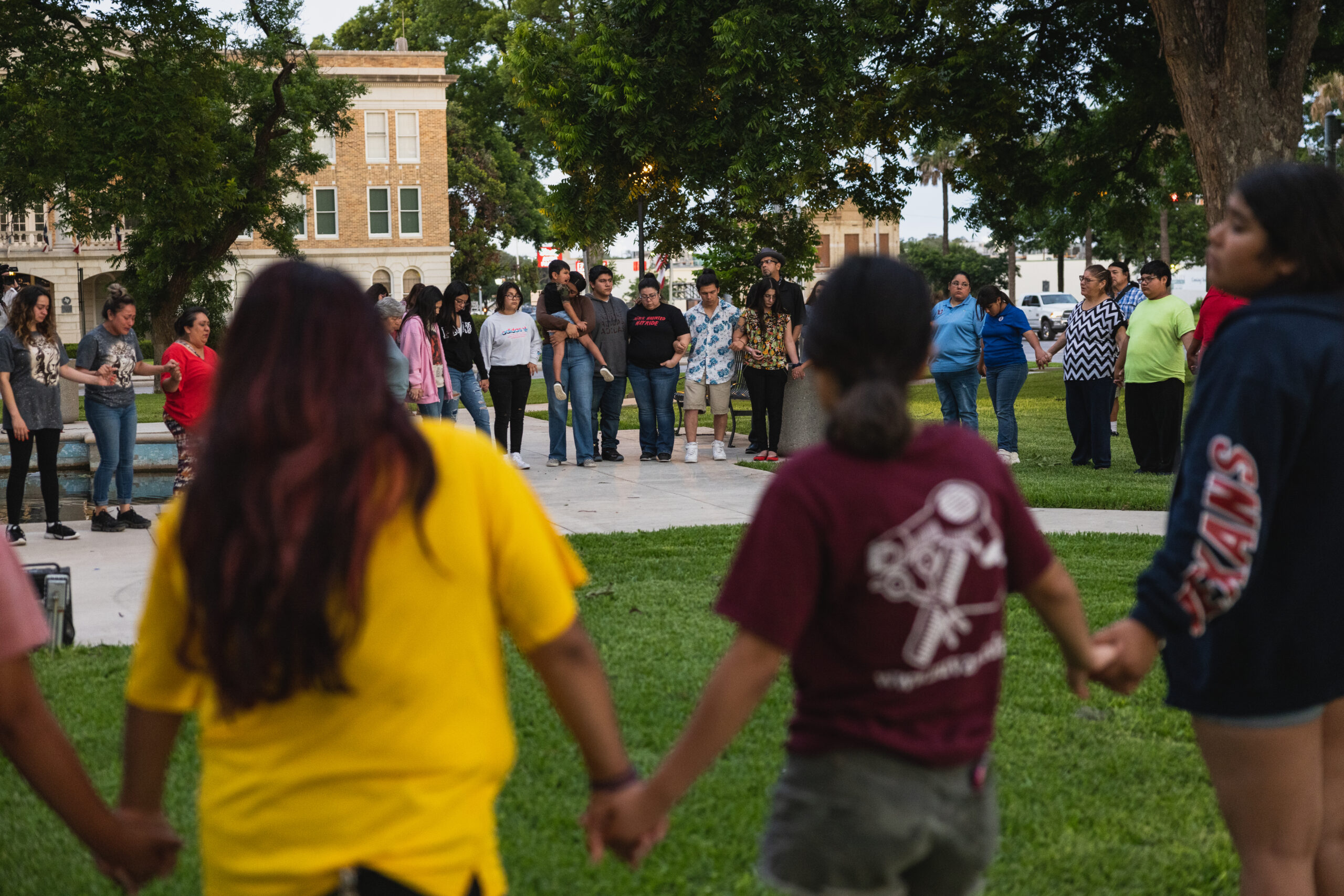 Residents of Uvalde hold hands in a large circle after elementary school mass shooting