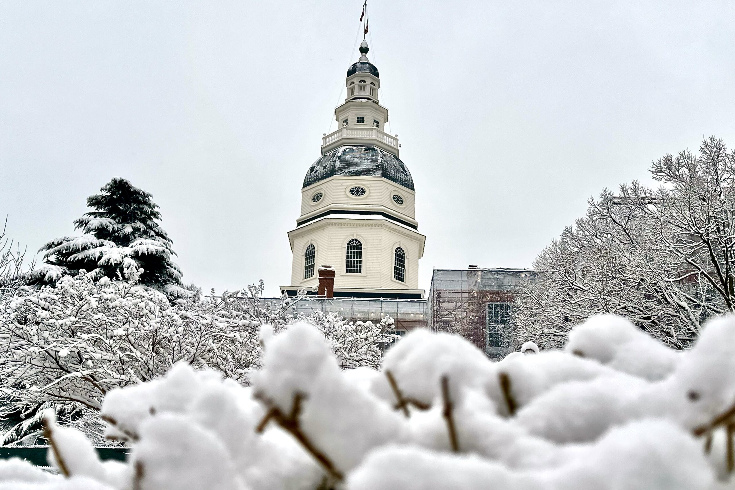 Maryland's iconic State House dome and grounds blanketed in newly fallen snow.